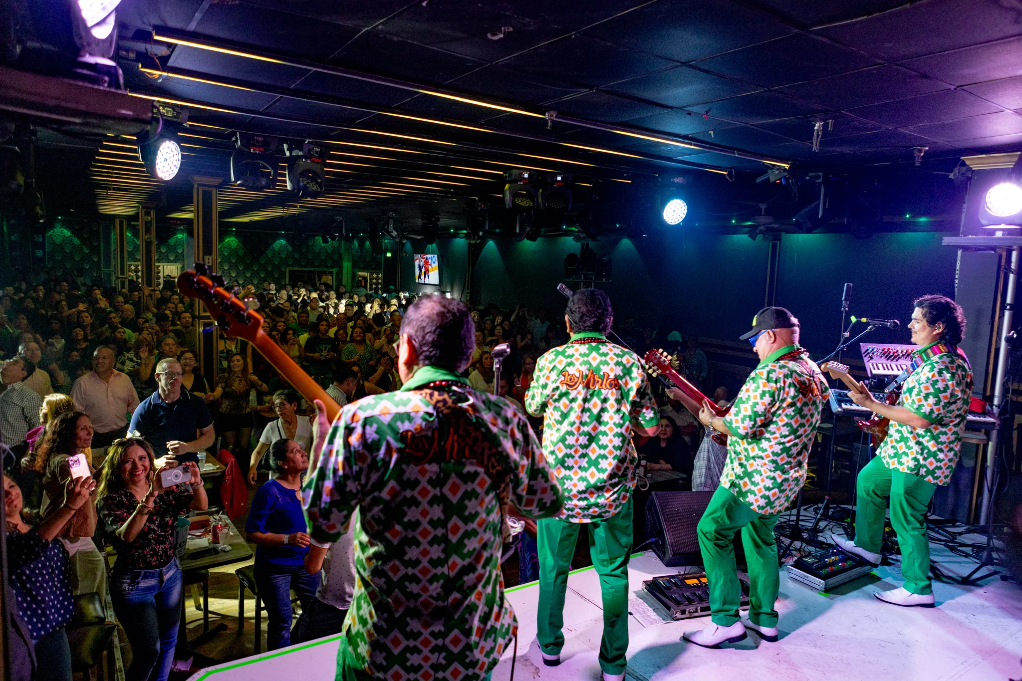 Performers on stage facing a packed live audience
